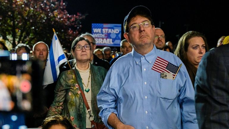 Attendees display signs and chant during a rally and vigil...