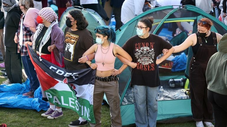 Stony Brook University students demonstrate on the grassy steps outside...