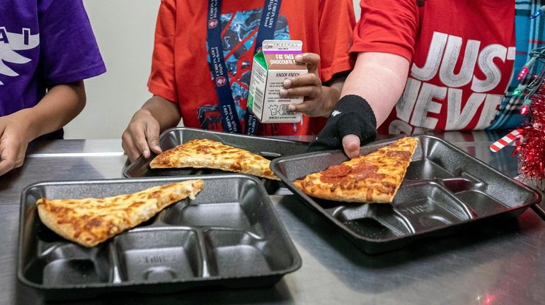 Second-grade students select their meals during lunch break in the...