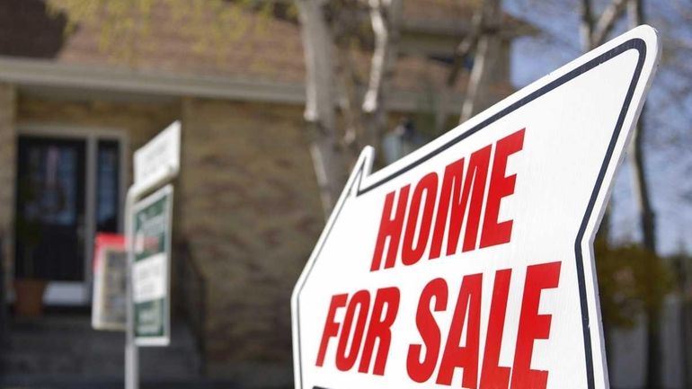 A for sale sign posted in front of a house.