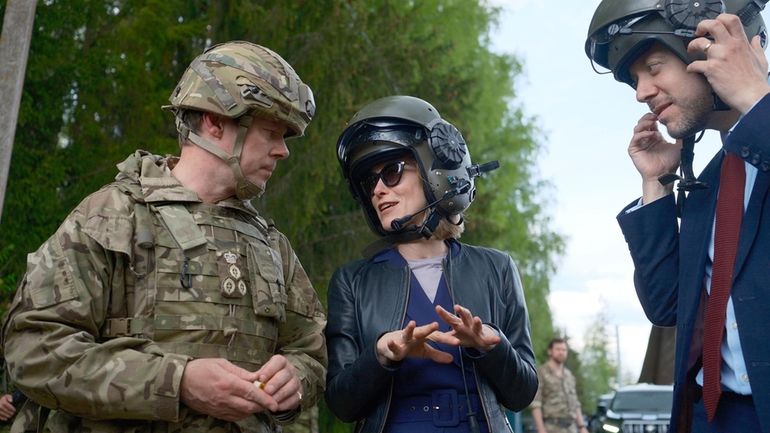 Estonian Prime Minister Kaja Kallas, center, speaks to Brig. Charles...