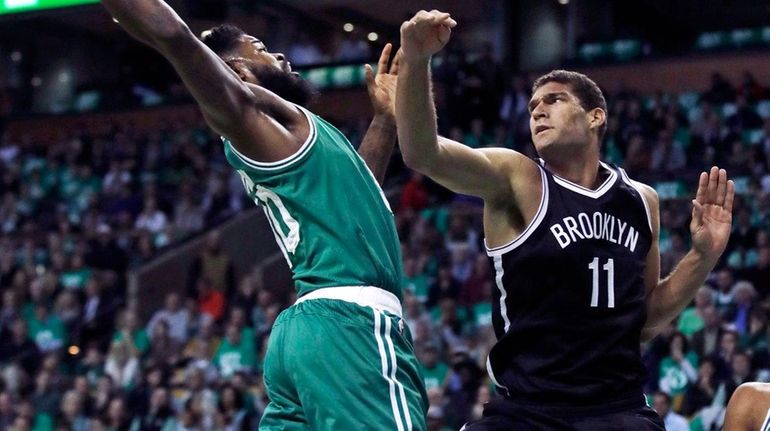 Boston Celtics forward Amir Johnson, left, grabs a rebound over...