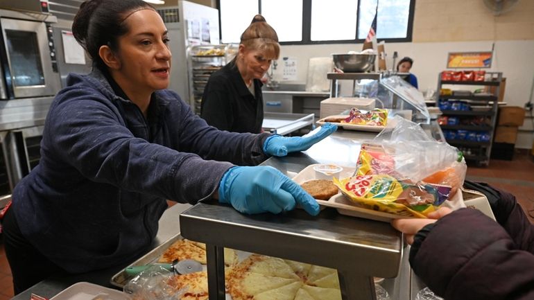 Cook Jillian LaGreco, left, and kitchen worker Gina Miller serve free...