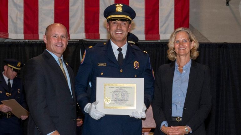 Nassau police Deputy Insp. Damian Ramos, center, with Commissioner Patrick J. Ryder...