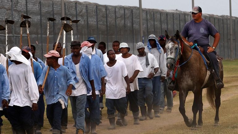 In this Aug. 18, 2011 photo, a prison guard rides...