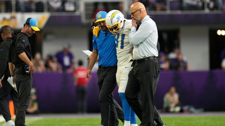 Los Angeles Chargers wide receiver Mike Williams (81) is helped...