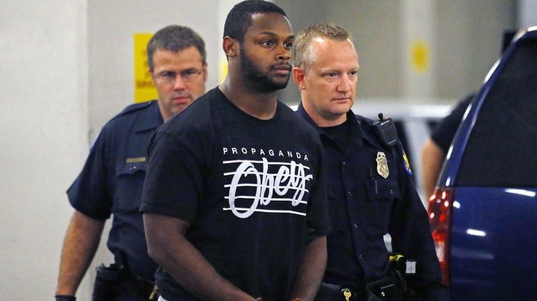 Phoenix police officers escort Arizona Cardinals running back Jonathan Dwyer...