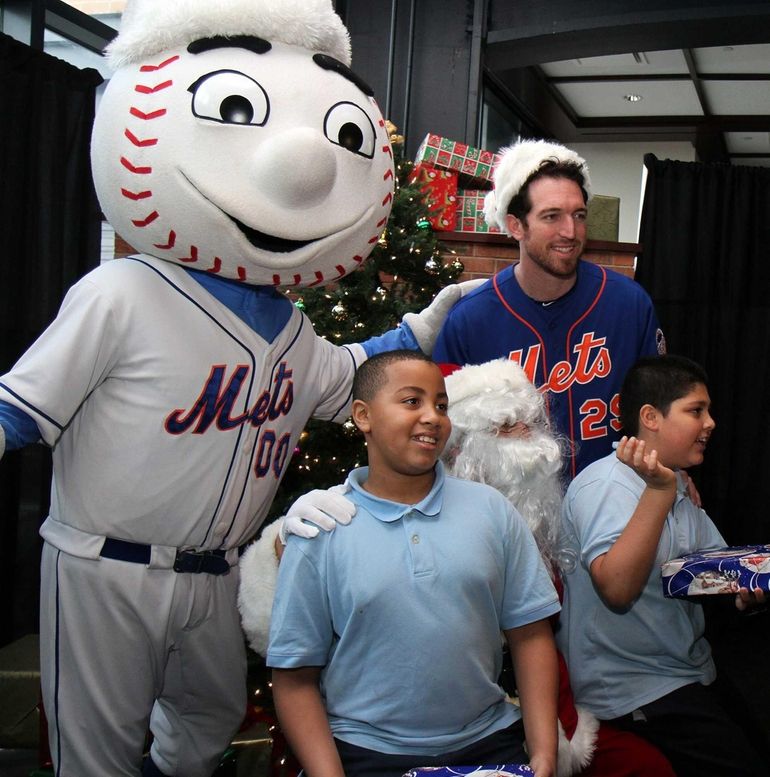 New York Mets outfielder Brandon Nimmo, center, dressed as Santa