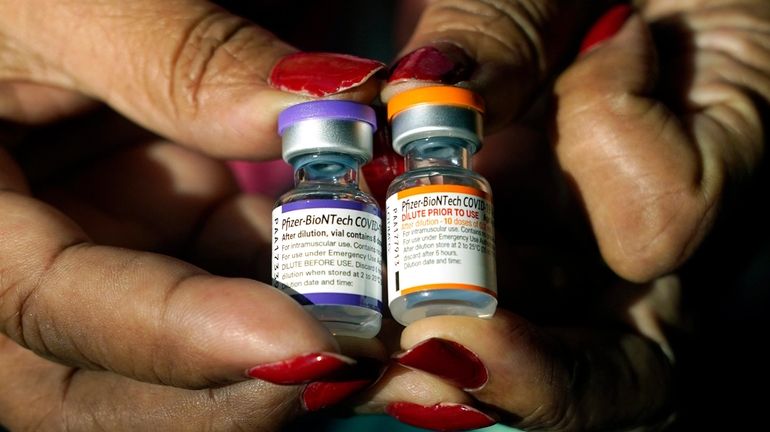 A nurse holds a vial of the Pfizer COVID-19 vaccine...