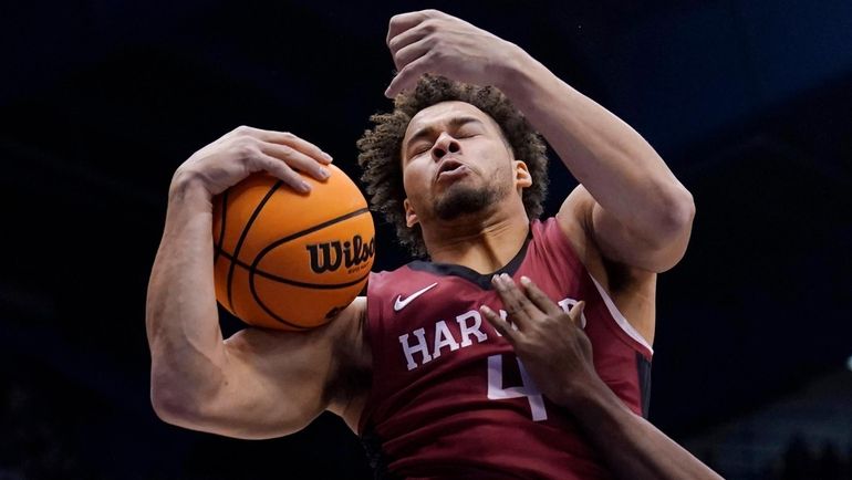 Chris Ledlumof the Harvard Crimson rebounds the ball against K.J....