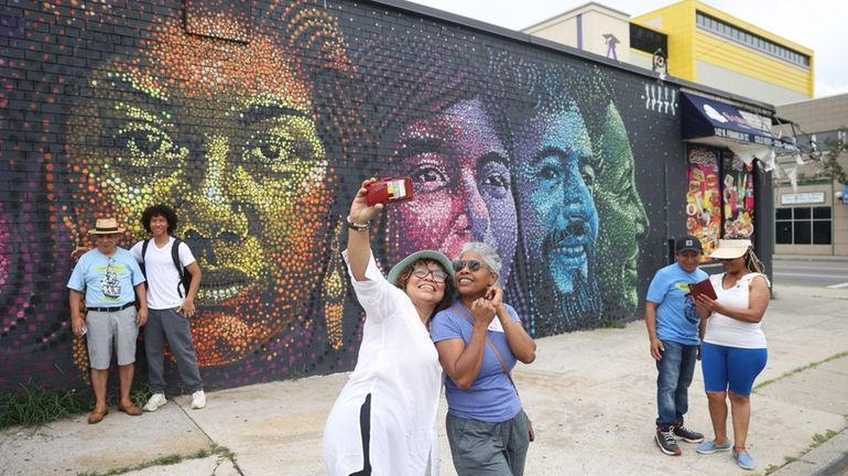 Irma Barahona, center, left, and Edith Rojas, take a selfie...