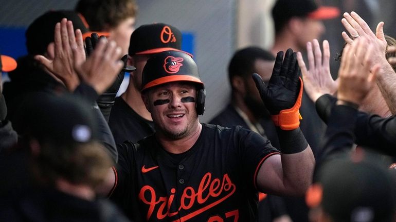 Baltimore Orioles' James McCann is congratulated by teammates in the...