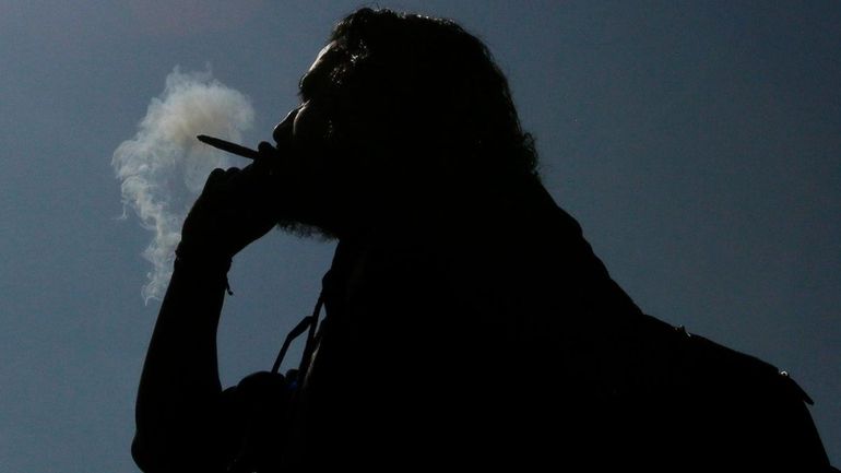 A man smokes a marijuana cigarette in Manhattan's Washington Square Park...