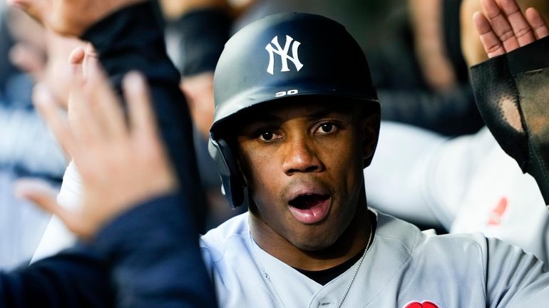 Yankees' Greg Allen is greeted in the dugout after scoring...