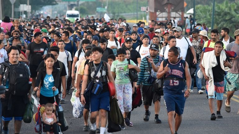 Migrants walk along the highway through Suchiate, Chiapas state in...