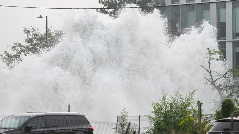 A broken water main spews water into the air on...