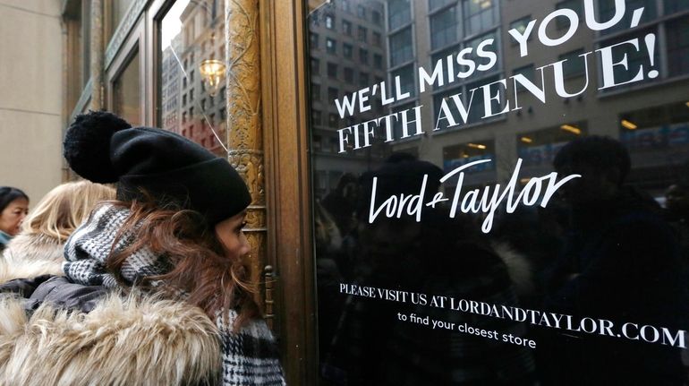 Women peer in the front door of Lord & Taylor's...