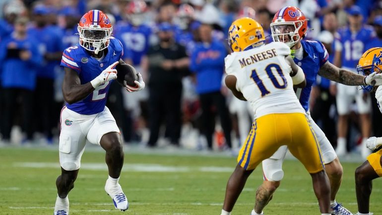 Florida running back Montrell Johnson Jr. (2) runs through an...