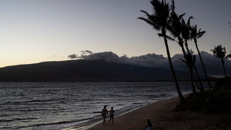 A couple walks along the beach in Kihei, Hawaii, Aug....