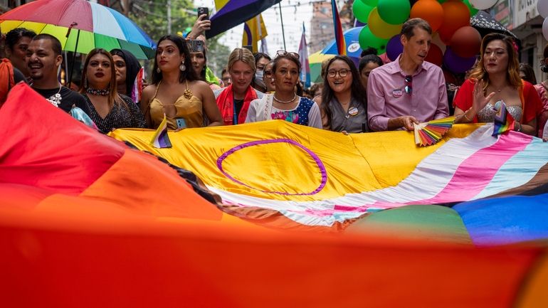 LGBTQ+ people and their supporters rally during the annual pride...