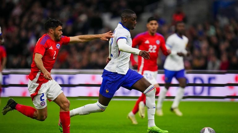 France's Randal Kolo Muani, right, is challenged by Chile's Gabriel...