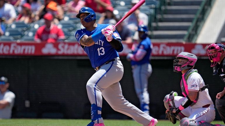 Kansas City Royals' Salvador Perez, left, hits a single as...