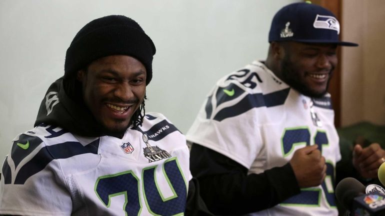 Seattle Seahawks' Marshawn Lynch, left, laughs with teammate Michael Robinson...