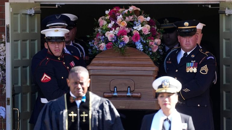 An Armed Forces body bearer team carries the casket after...