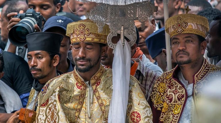 A priest cries during a mass funeral at the Holy Trinity Cathedral in...