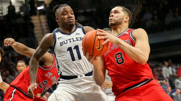 St. John's Chris Ledlum drives past Butler's Jahmyl Telfort to the basket...