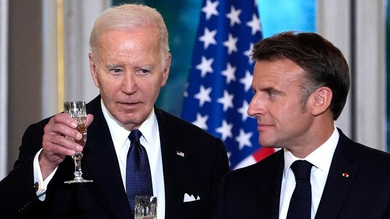 French President Emmanuel Macron, right, and President Joe Biden toast...