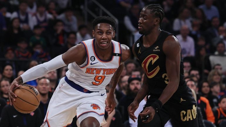 Knicks guard RJ Barrett dribbles by Cavaliers guard Caris LeVert in the...