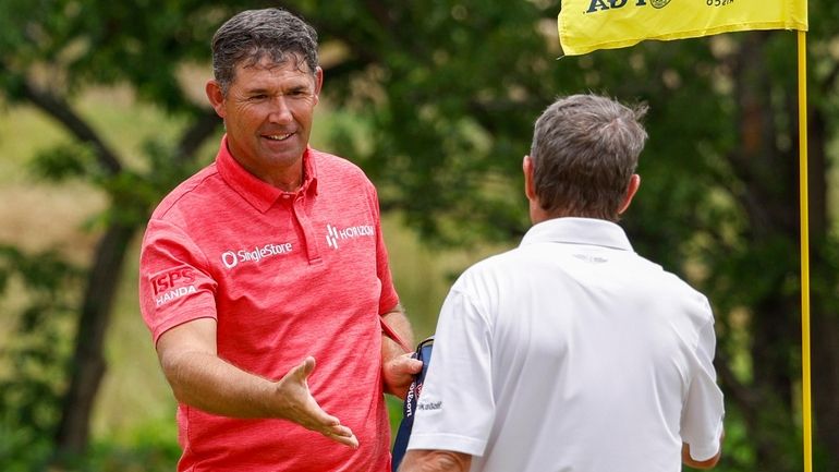 Padraig Harrington of Ireland (left) shakes hands with Steven Alker...