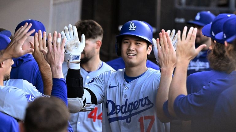 Los Angeles Dodgers designated hitter Shohei Ohtani, center, celebrates in...