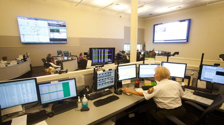 Ethel Hoenig, police communications operator supervisor, sits at a command...