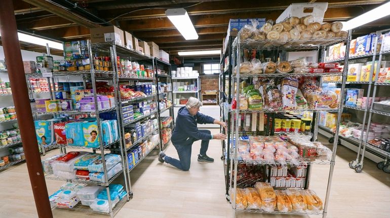 CAST volunteer Biff Harney stocks shelves Nov. 18 in the food...