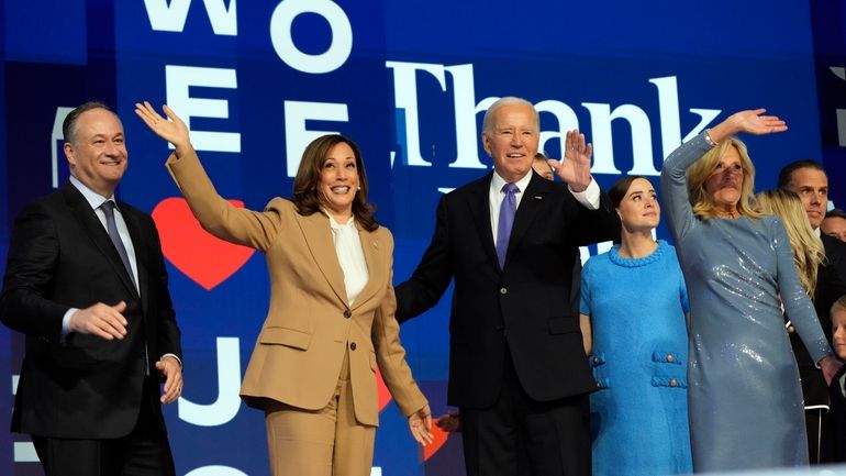 President Joe Biden and first lady Jill Biden stand on...