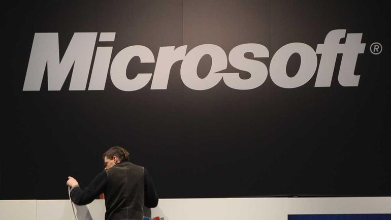 A worker helps prepare the Microsoft stand the day before...