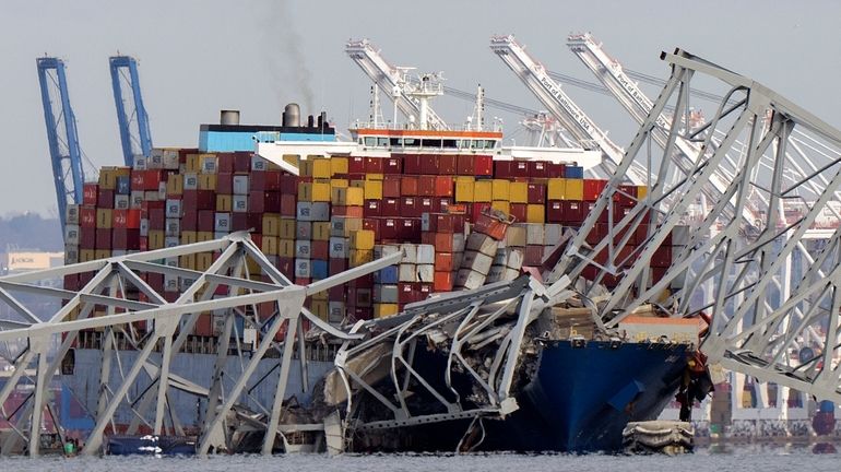 The cargo ship Dali is stuck under part of the...