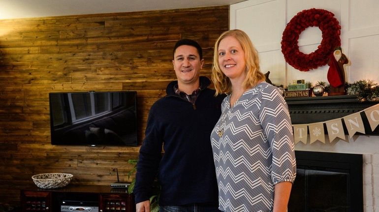 Steven and Tara Poli in front of the wooden feature...