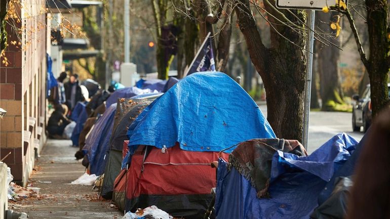 Tents line the sidewalk on SW Clay St in Portland,...