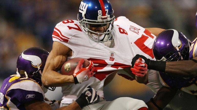 Giants receiver Domenik Hixon is brought down by Minnesota's Jamarca...