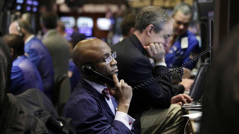 Trader Lewis Vande Pallen watches monitors Monday on the floor...