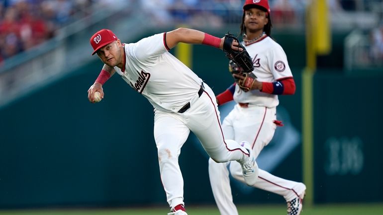 Washington Nationals third baseman Nick Senzel, left, throws an infield...