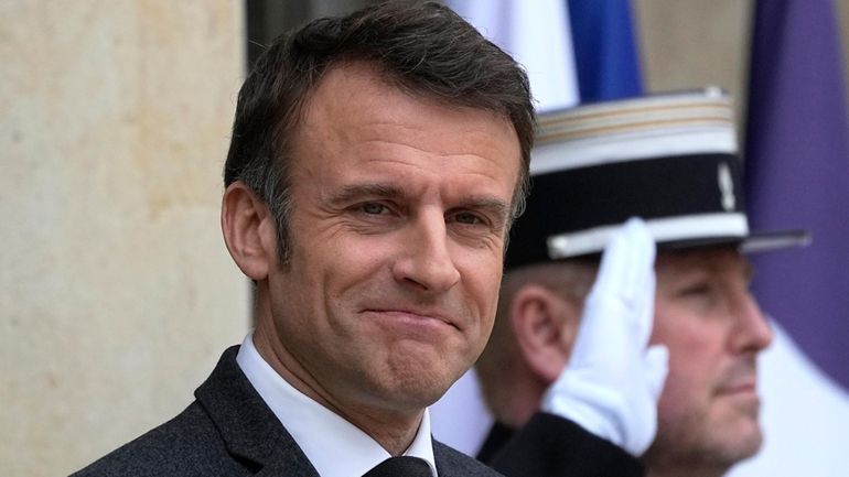 French President Emmanuel Macron waits on the steps of the...