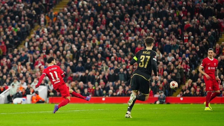 Liverpool's Mohamed Salah, left, scores his side's third goall during...