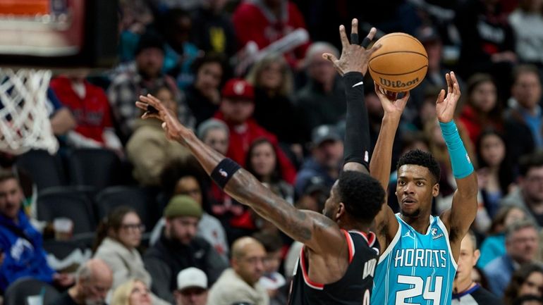 Charlotte Hornets forward Brandon Miller, right, looks to shoot over...