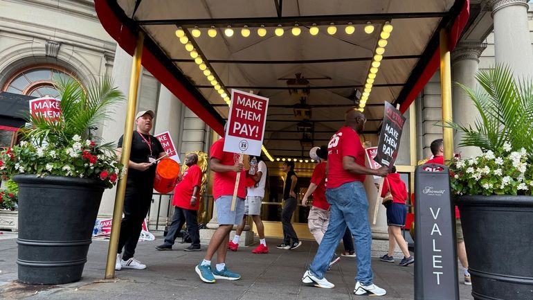 Hotel workers on strike chant and beat drums while picketing...