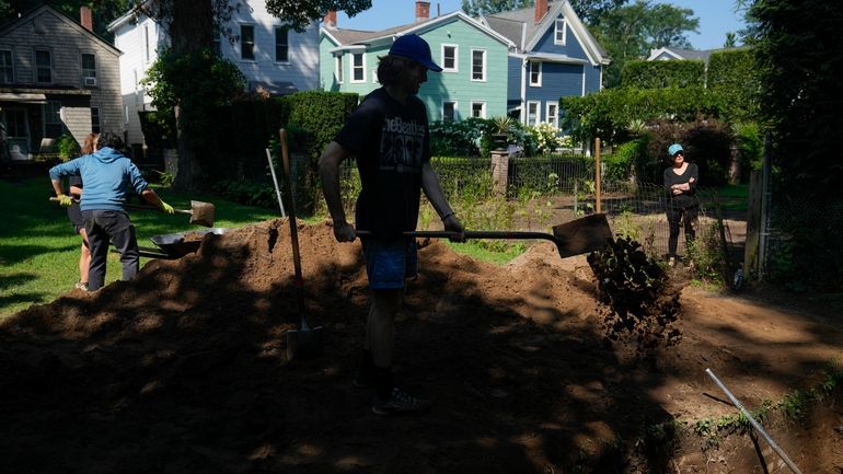 Students working at the site of an African burial ground,...