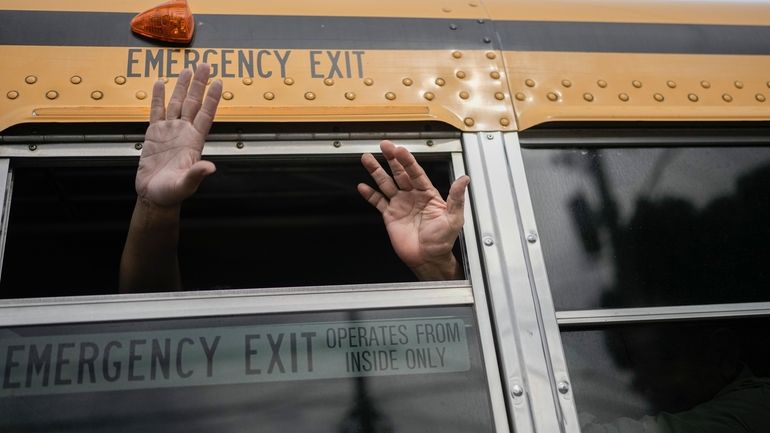 Nicaraguan citizens wave from a bus after being released from...